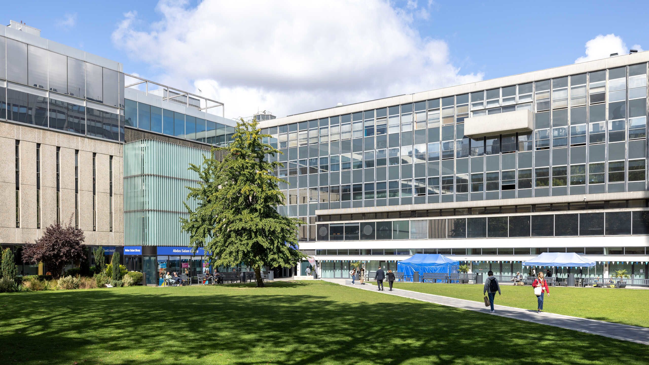 Students on the Dangoor Plaza in the sunshine, surrounded by Imperial buildings including the Library and the Sherfield building, which houses the Disability Advisory Service