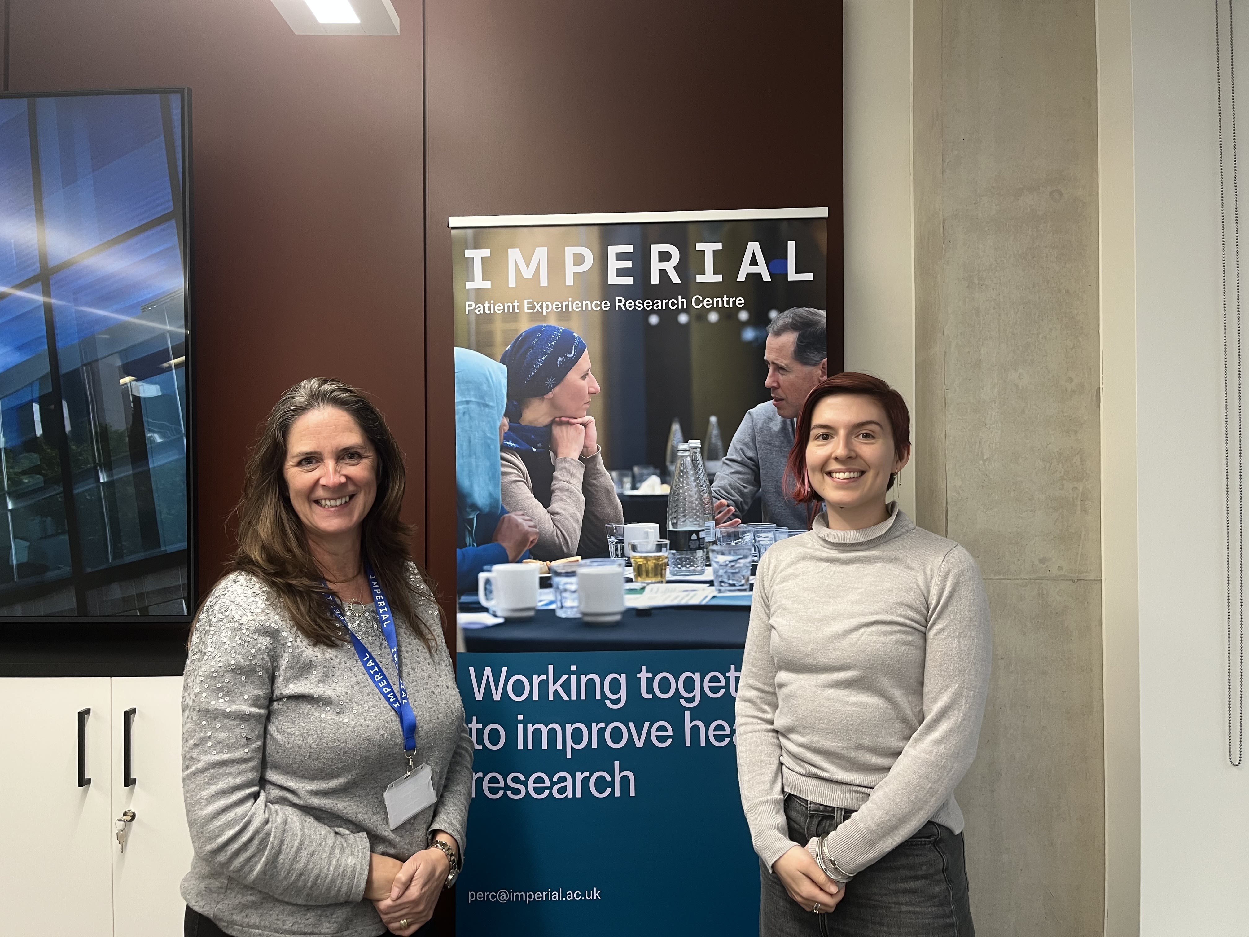 Imperial PERC Fellows smiling in front of a banner 