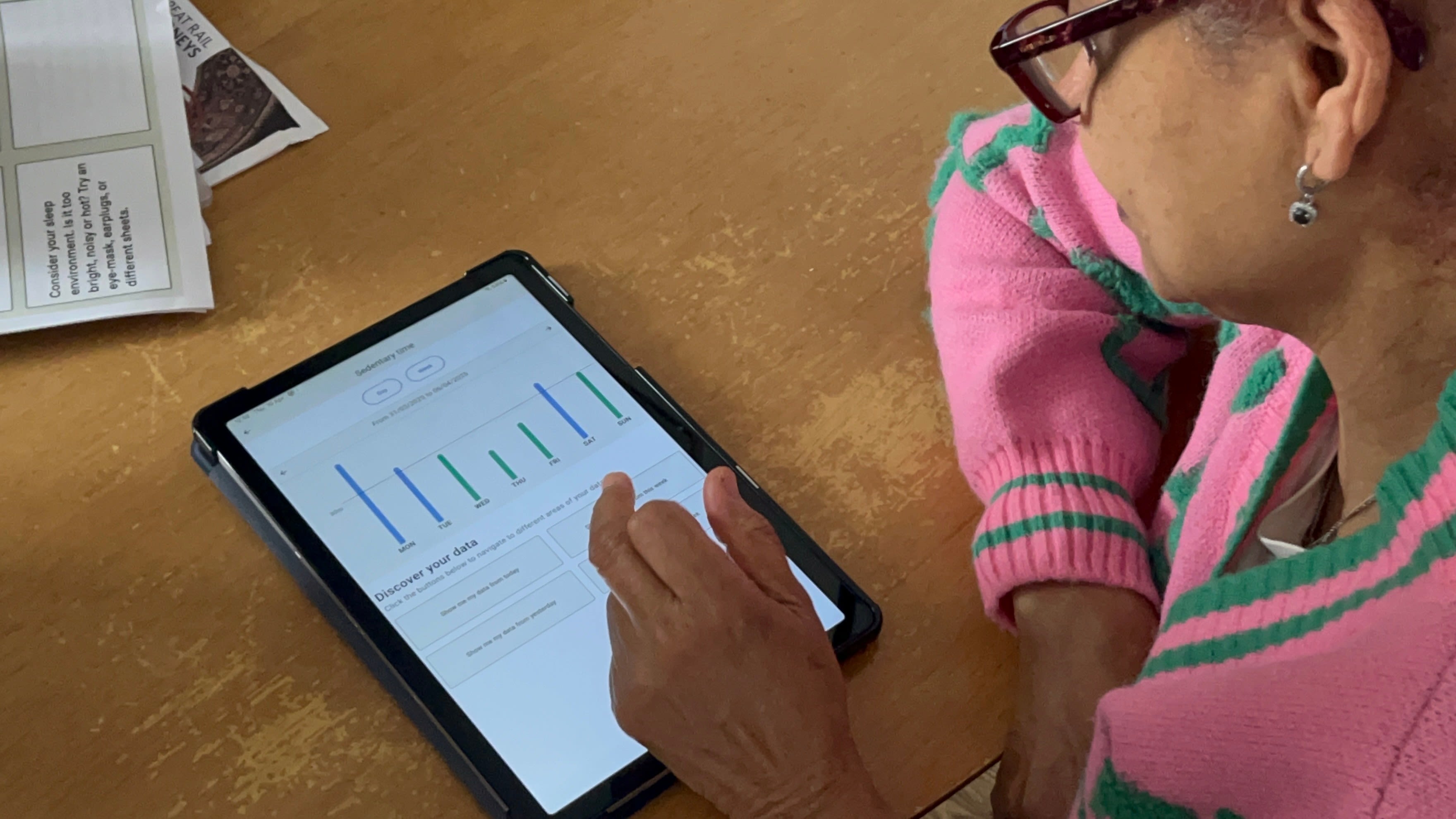 A woman with glasses checks data on a mobile device