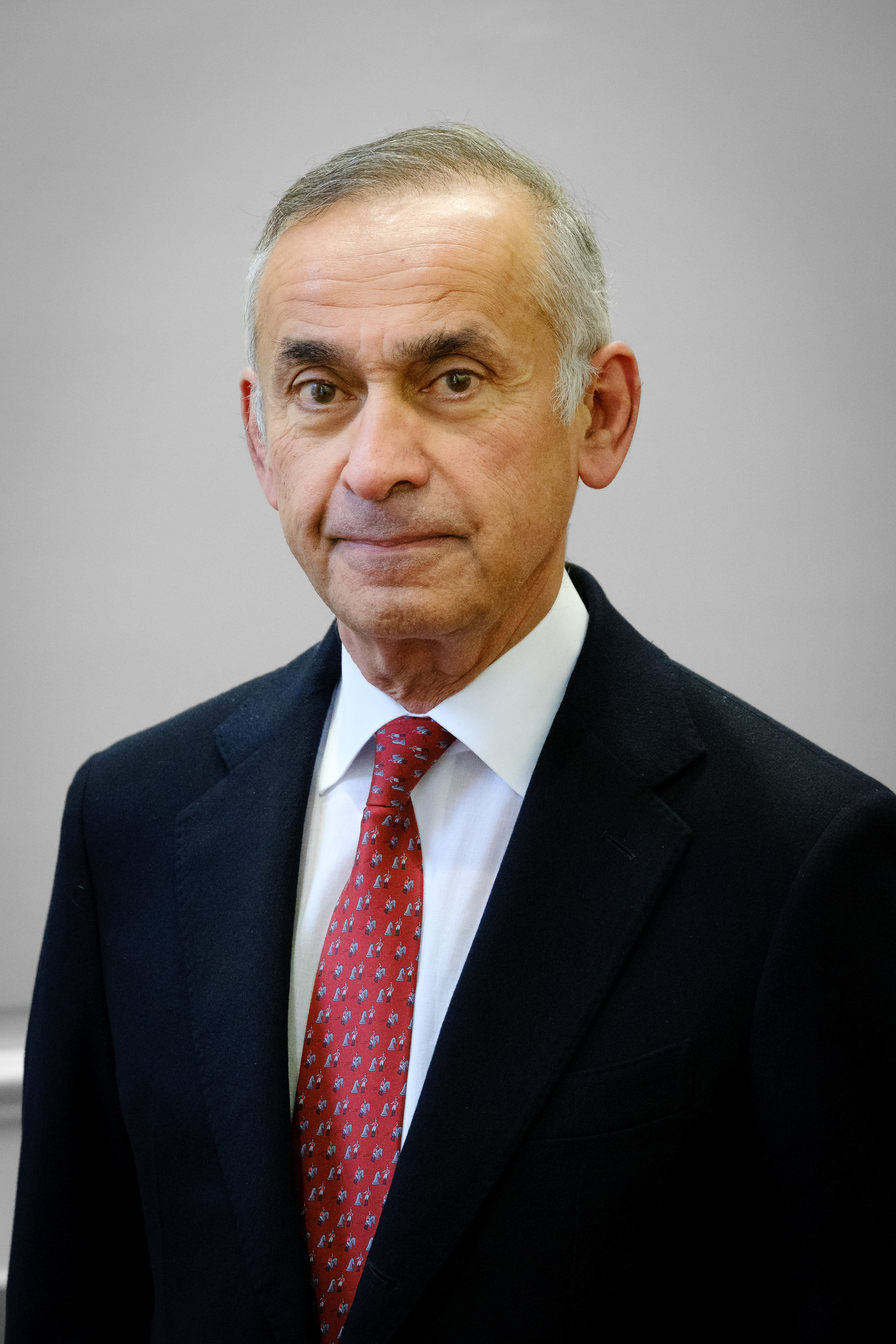 A picture of Professor Lord Ara Darzi wearing a suit and tie, standing