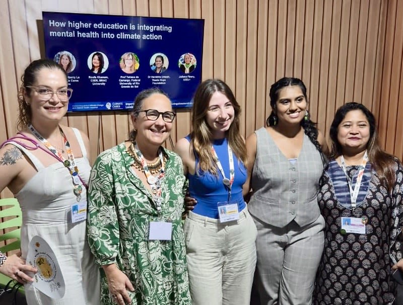 A smiling group of five women standing