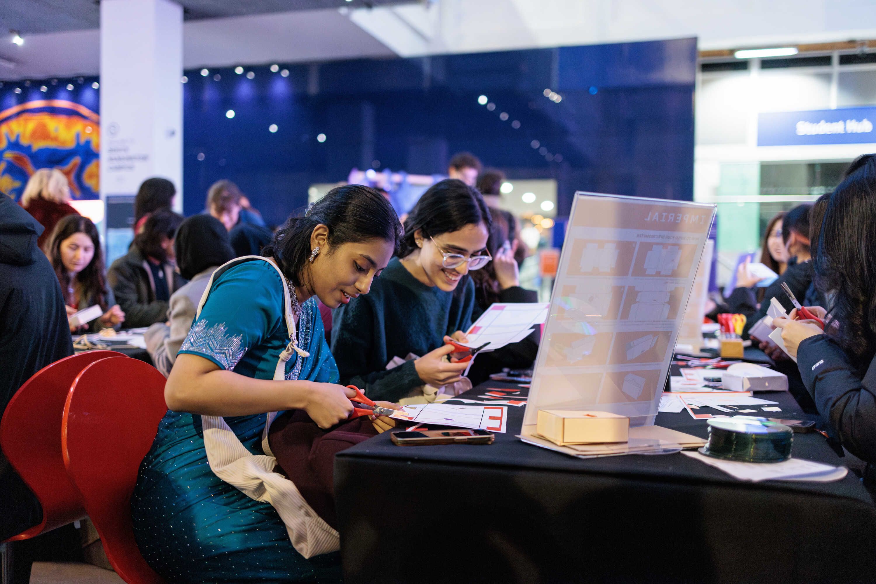 Two women smiling as they work on a craft project