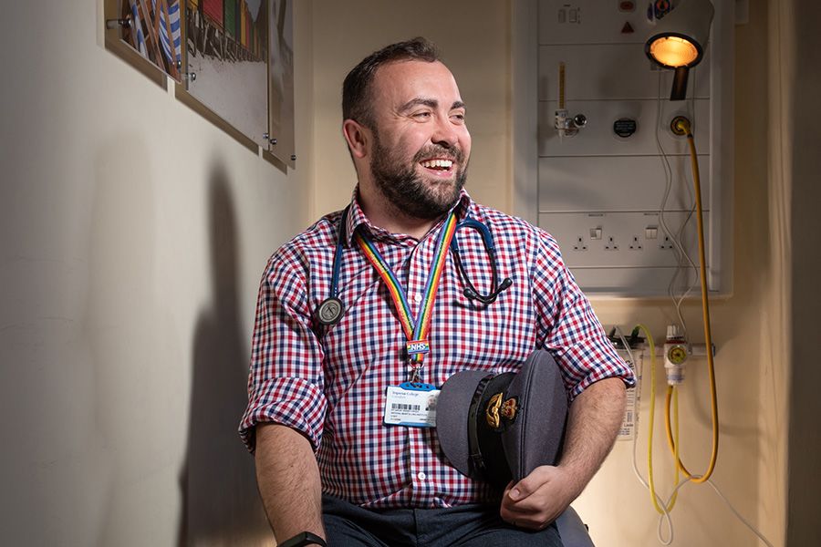 Aaron sits smiling in clinical room