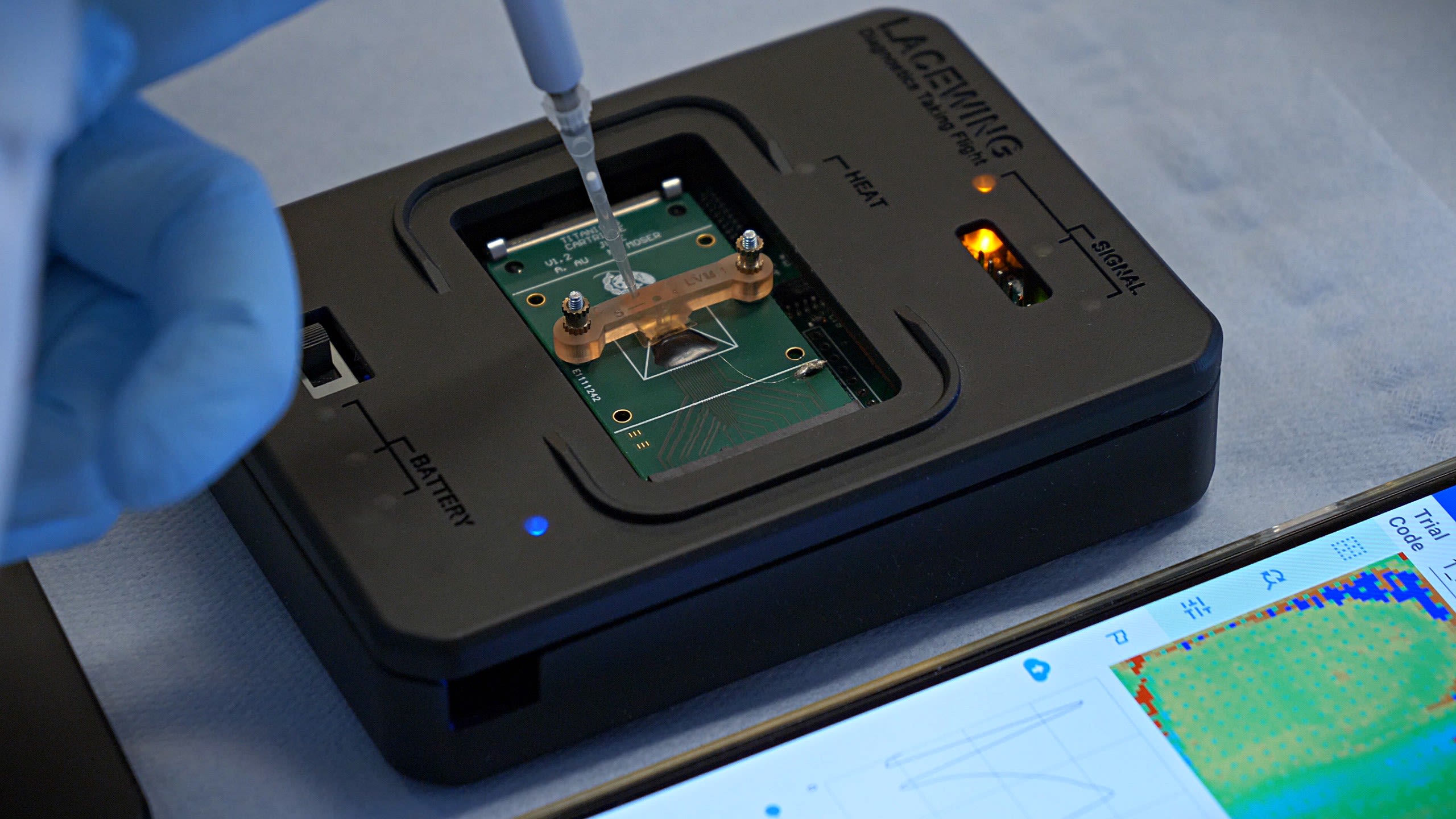 Close-up of a gloved hand tweaking some electronics in a small box