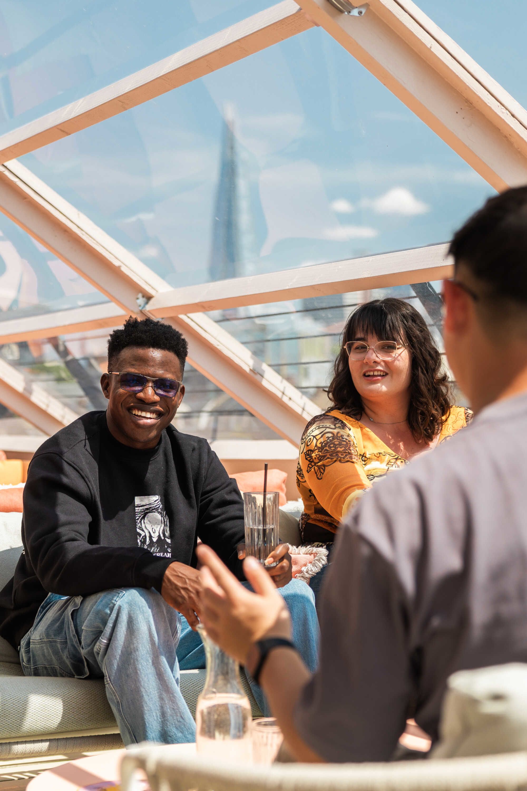 Students chatting at a rooftop cafe with the Shard building in the distant background