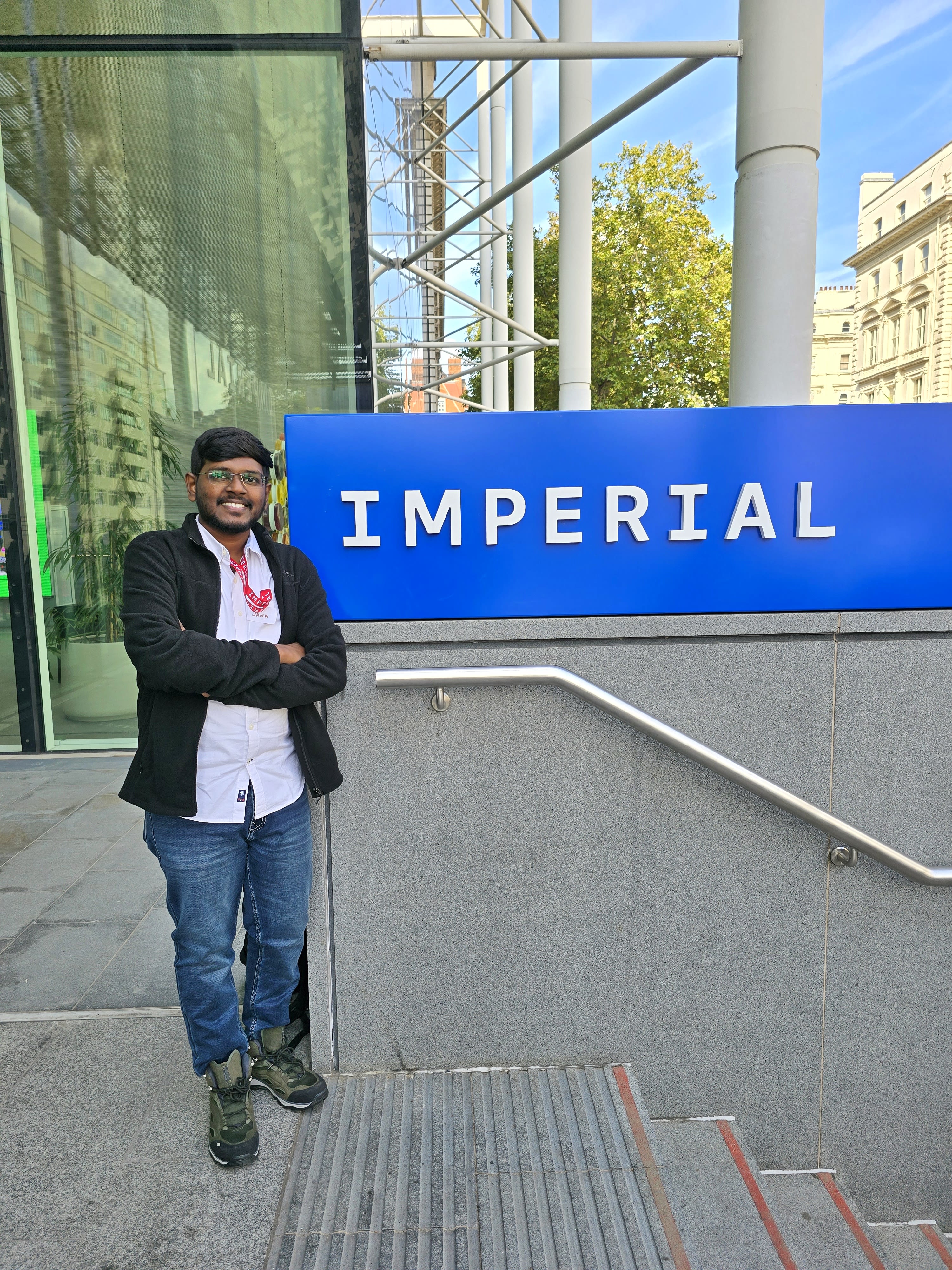 Janarathanan standing next to an Imperial sign
