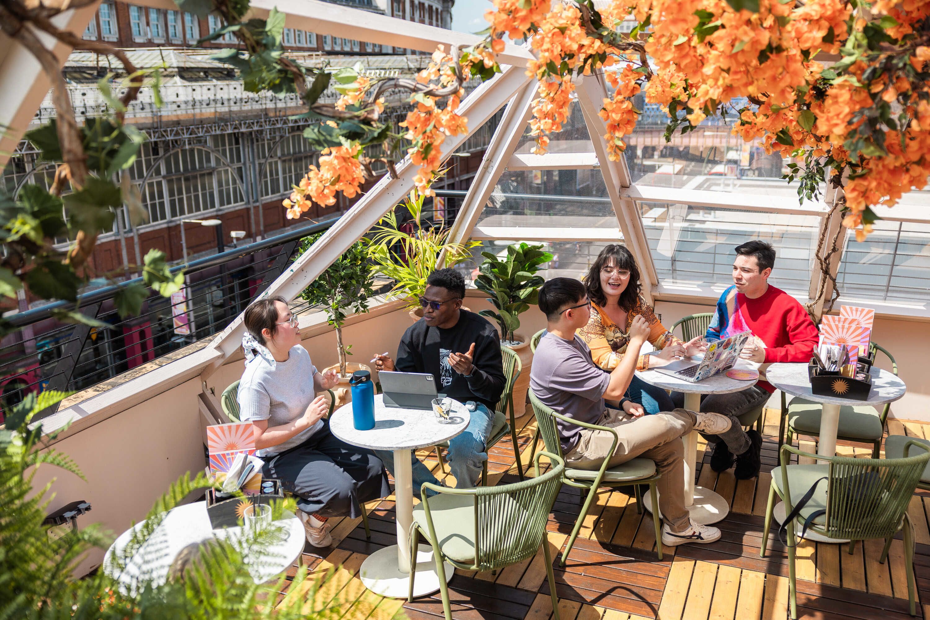 Groups of students working and chatting at a rooftop cafe
