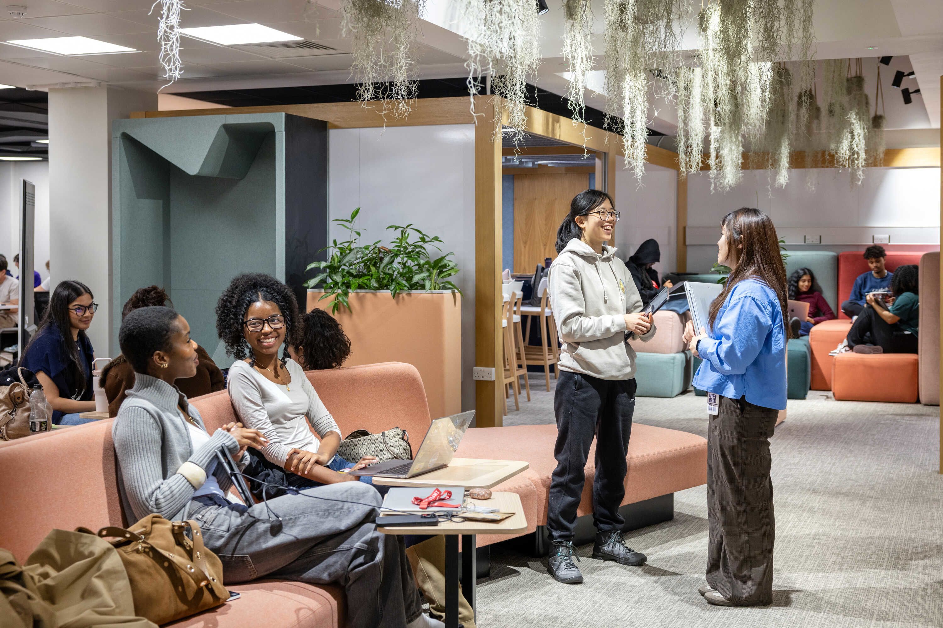 Students in a shared student space with a variety of couches and seating areas