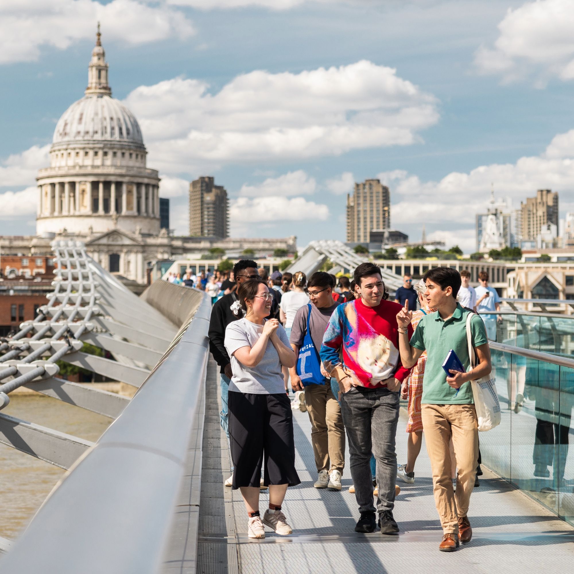 Group of students walking on a bridge with St Paul's Cathedral in London in the background