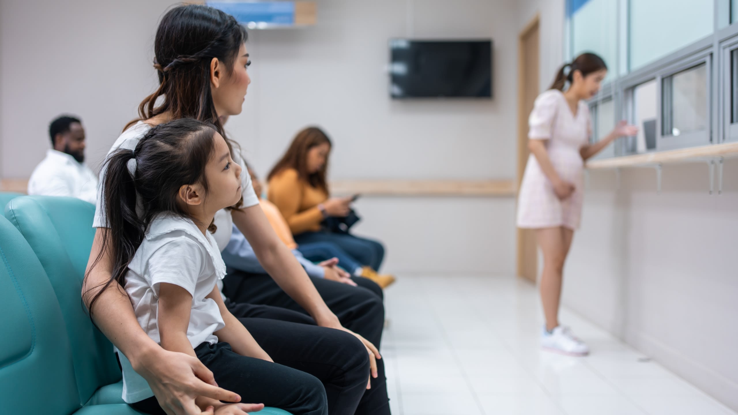 Child and mother sit in hospital waiting room