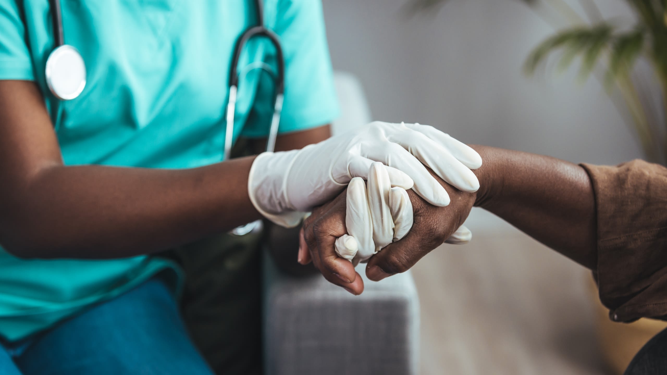 Healthcare worker holds hand of patient