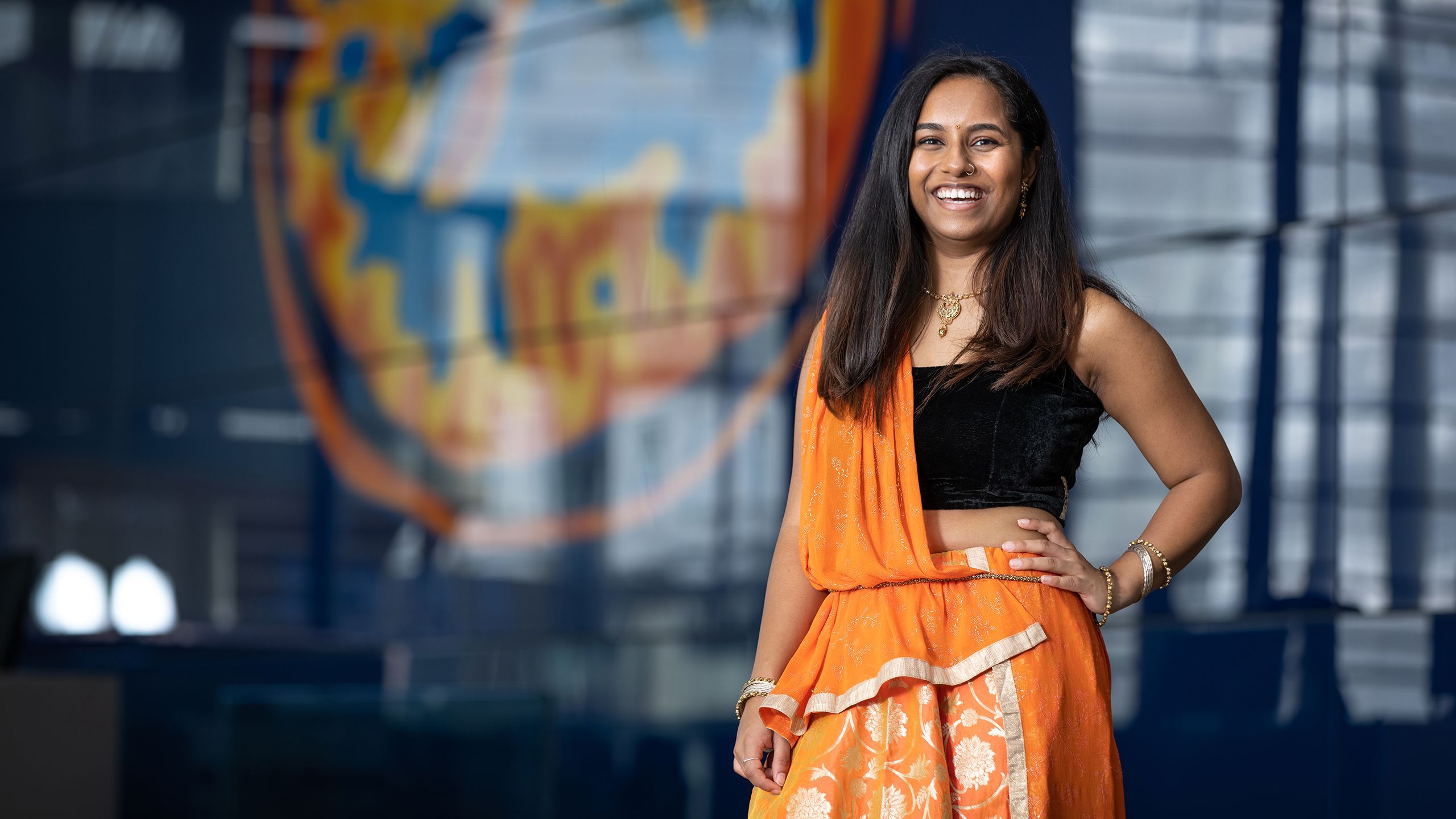 Nandini in 'lengha' outfit smiling at camera with hand on hip