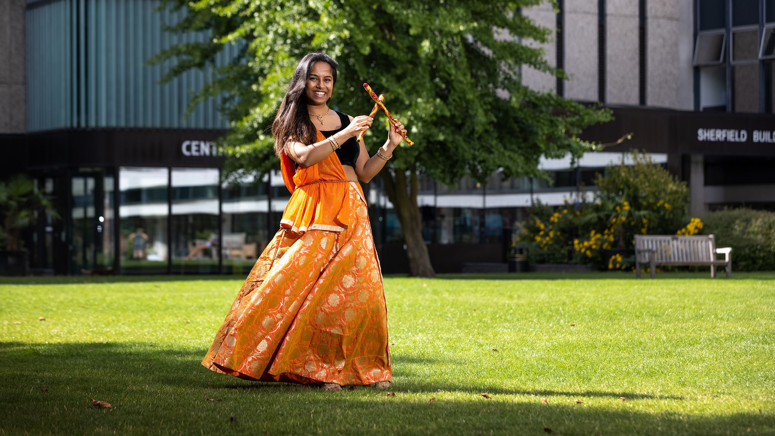 Nandini is pictured in her 'lengha' outfit holding dancing sticks in the air.