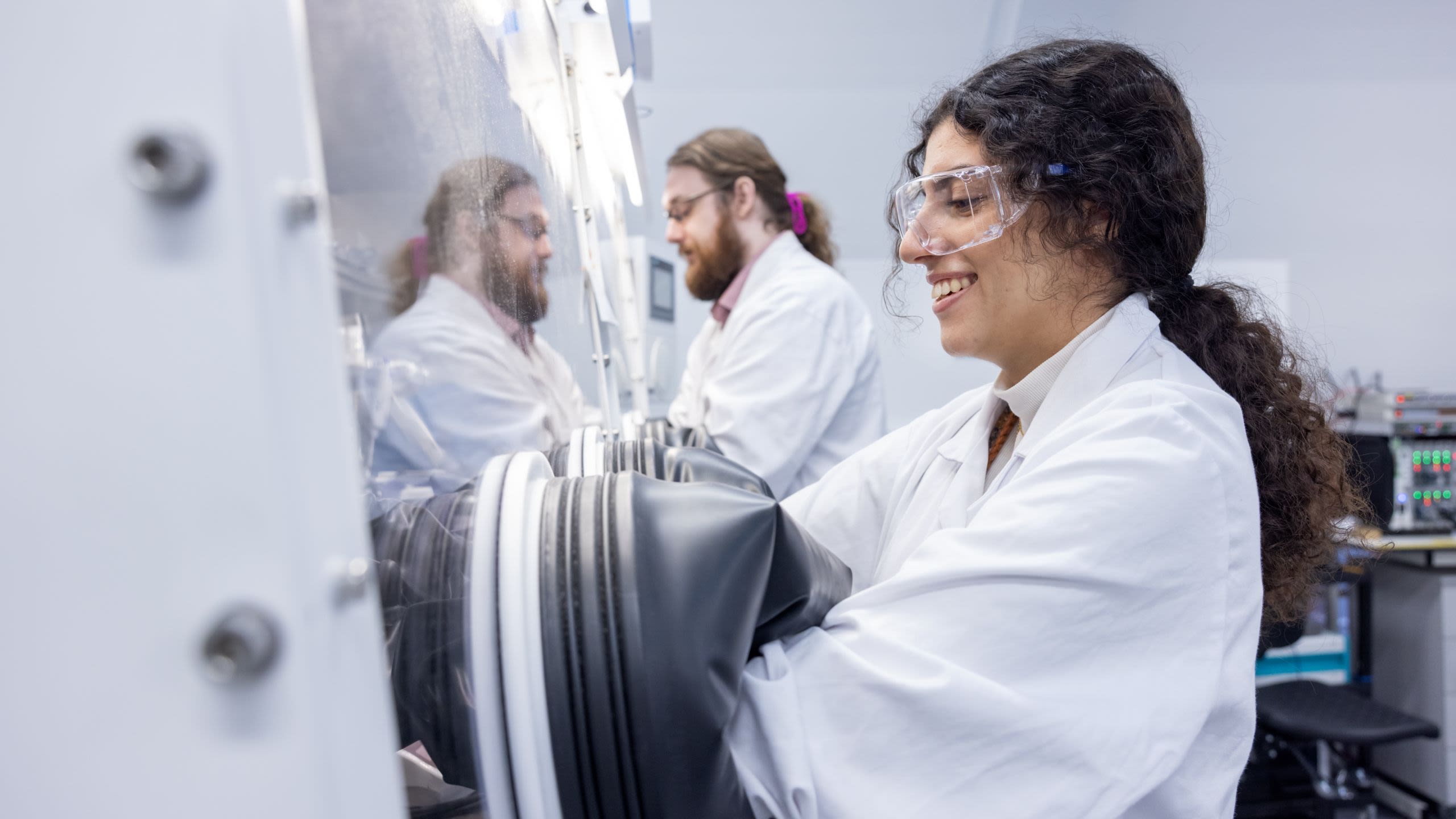 Ulah in the lab using special gloves to access a cabinet