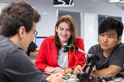 Students looking at robotic equipment