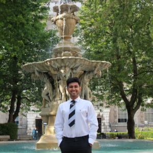 Student standing in front of a fountain