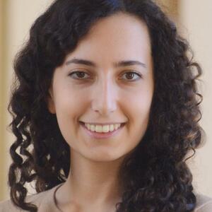 Headshot of a woman with curly hair standing in front of a beige background. Jasmin Moshfegh - New academic - 2025-26
