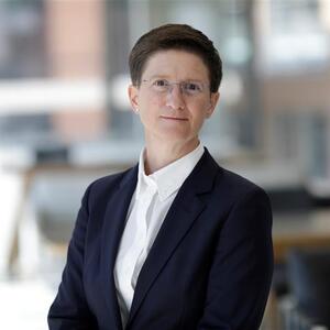 A professional headshot of Dame Julia Hoggett DBE