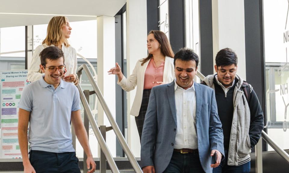 Five Imperial College Business School students walking down a staircase