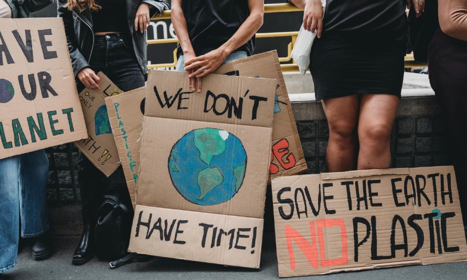 People holding banner signs at a demonstration against climate change