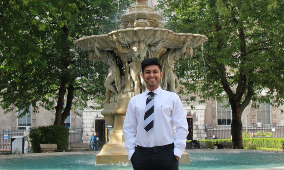 Student standing in front of a fountain