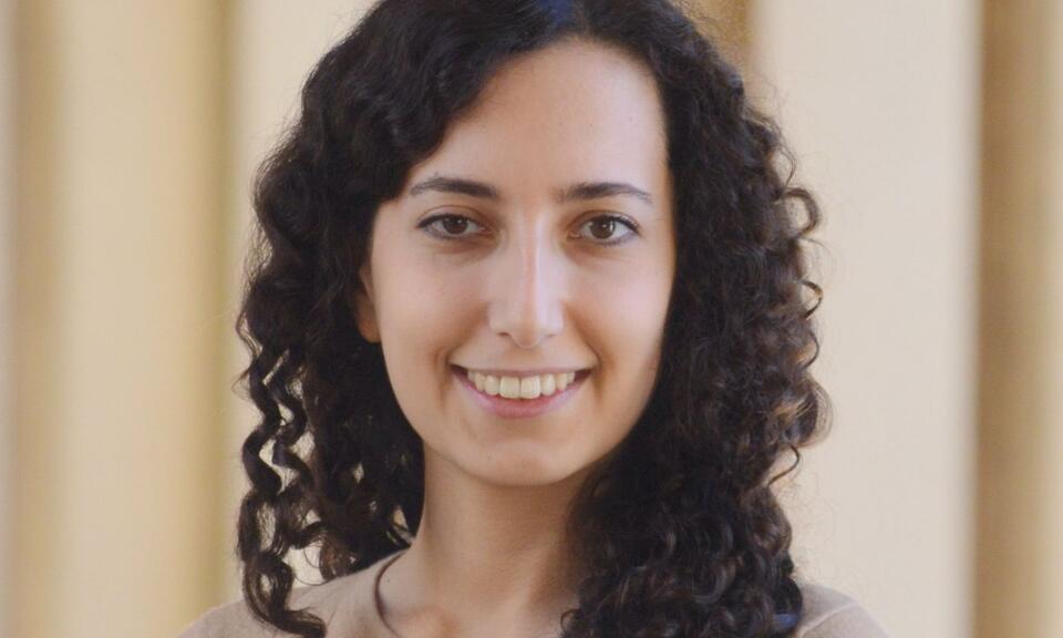 Headshot of a woman with curly hair standing in front of a beige background. Jasmin Moshfegh - New academic - 2025-26