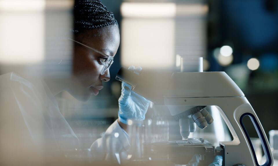 Scientist, microscope and analysis in lab for healthcare, innovation and development
