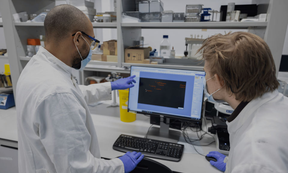 Two researchers in a lab looking at a computer screen