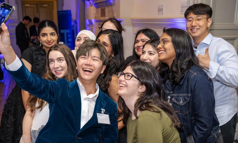 group of event attendees taking a selfie and smiling