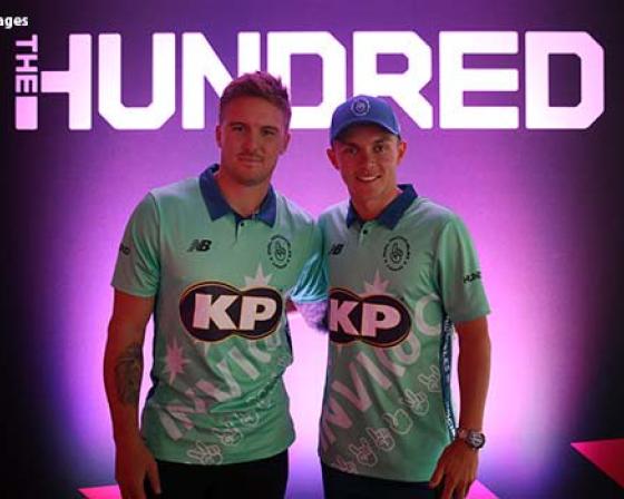Two athletes wearing 'KP Snacks' branded sports t-shirts