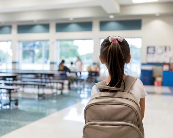 A schoolchild stands in a canteen