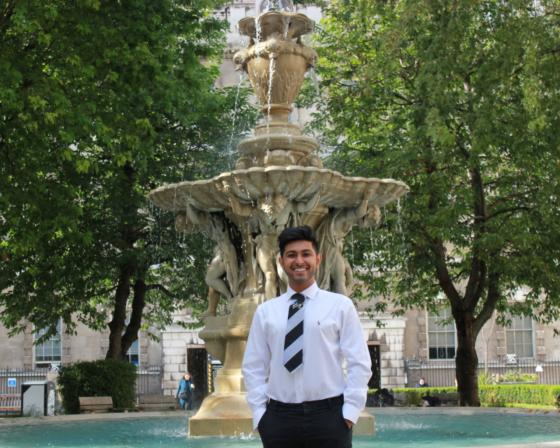 Student standing in front of a fountain