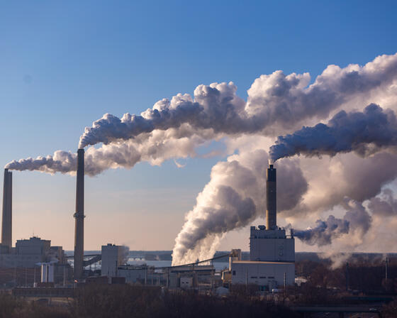 Plumes of smoke rise above a working coal processing plant, emissions rise into the sky.
