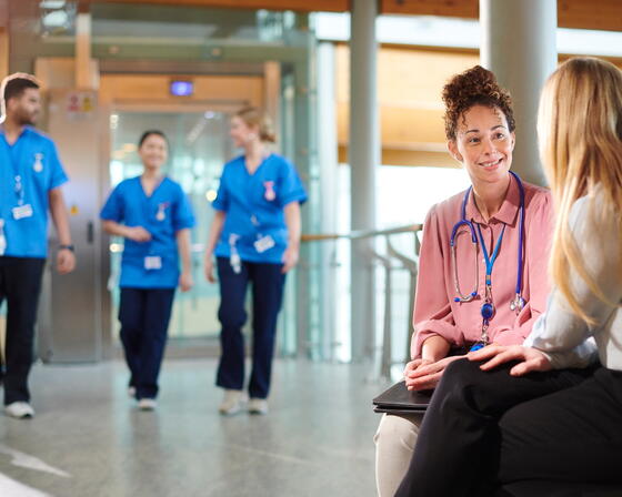 Doctor chatting with hospital visitor - stock photo
