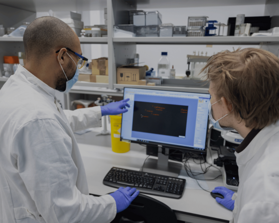 Two researchers in a lab looking at a computer screen