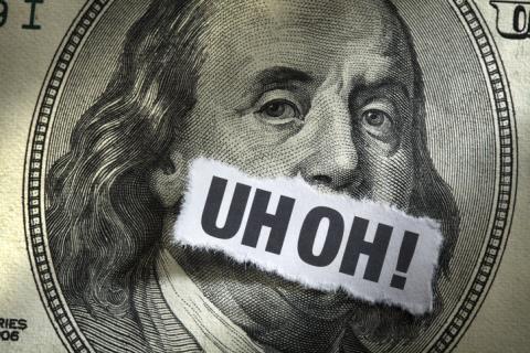 A $100 bill with the words "Uh Oh!" over Benjamin Franklin's mouth