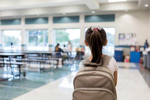 A schoolchild stands in a canteen