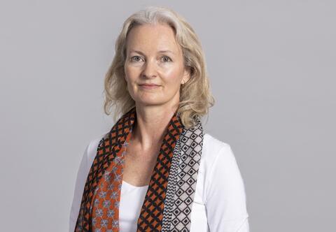 Picture of Pernille Holtedahl wearing a white top and colourful scarf around her neck. 