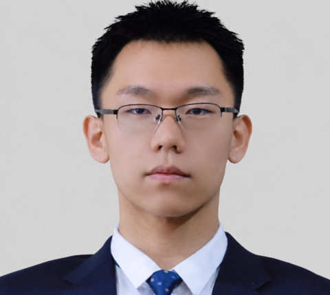 Man with short hair wearing glasses and a suit