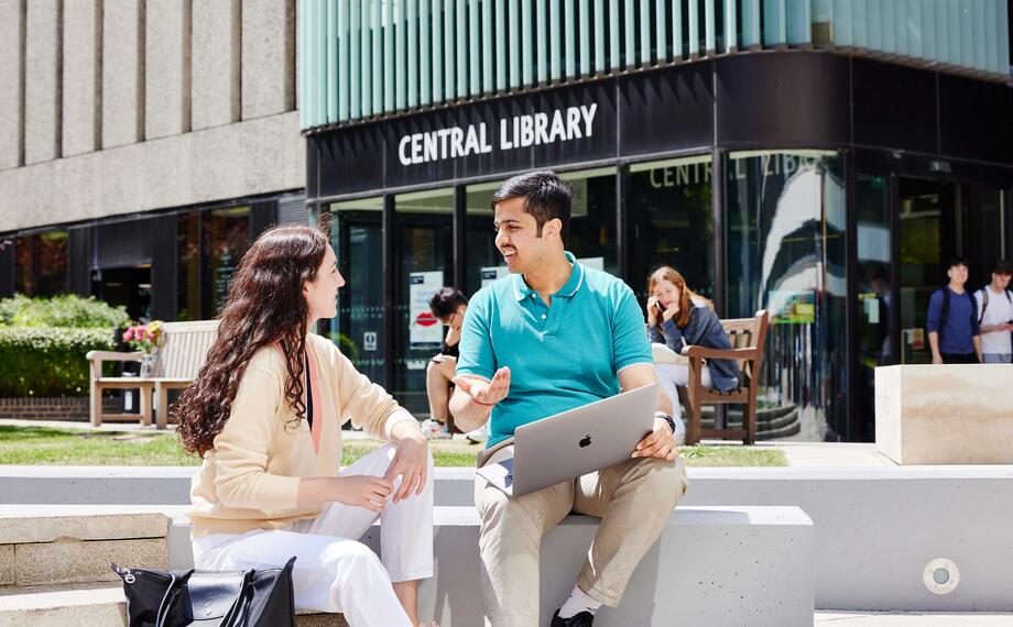 Two students sitting outside central library