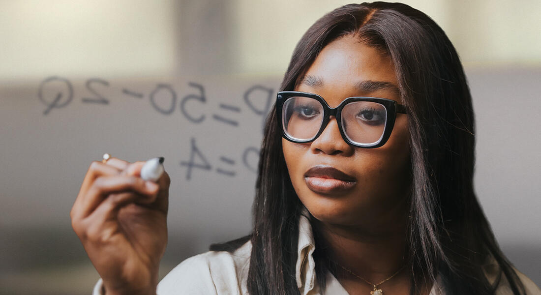 Imperial MSc Innovation, Entrepreneurship & Management student on campus in London writing an equation on a clear board
