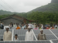 People in a rural setting in India standing around solar panels