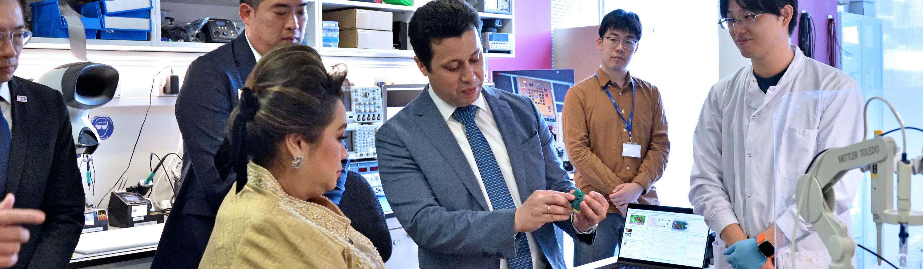 Prof Georgiou showing a printed circuit board to the Thai Science Minister