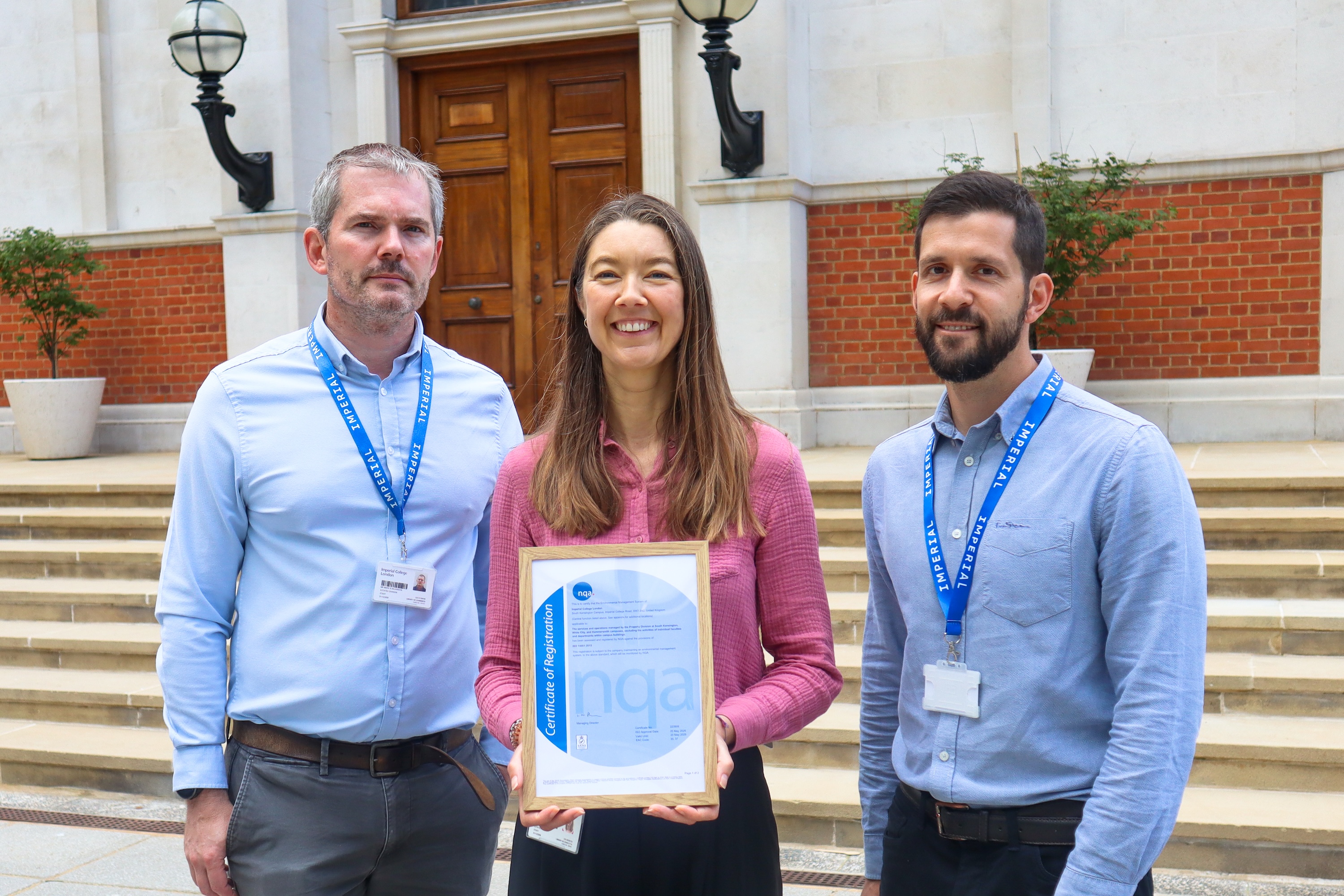 Mark Wilkinson, Lisa Holland and Alex Hobbins outside the Queen's Tower with Imperial's EMS certificate.
