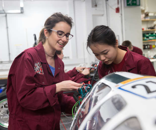 two mechanical engineers working on a car