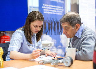 An Imperial researcher in discussion with a patient