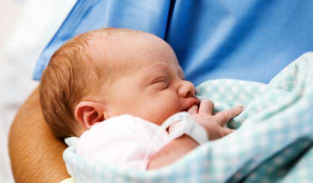 Baby in arms of nurse