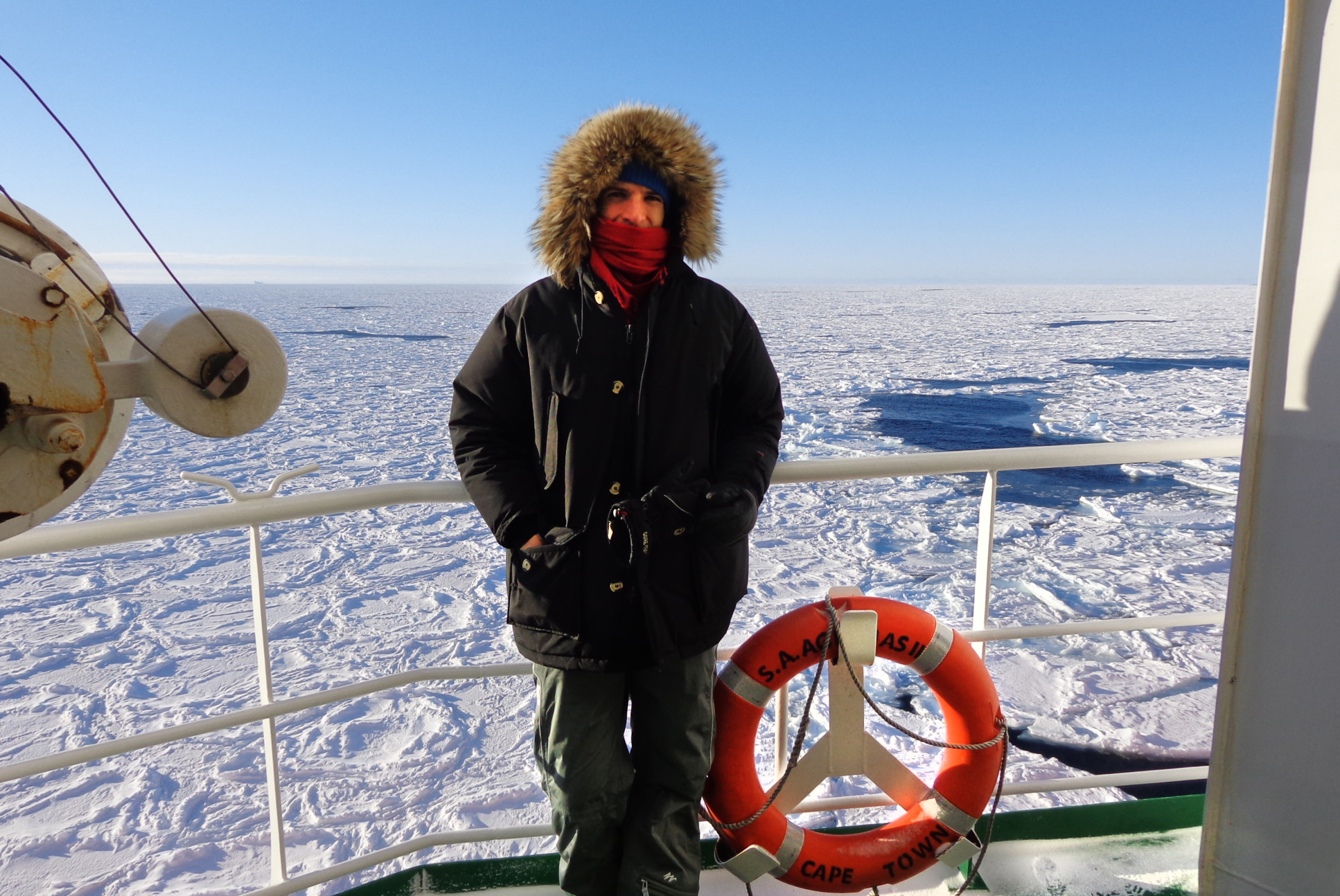 The subject of the article standing on a boat surrounded by ice