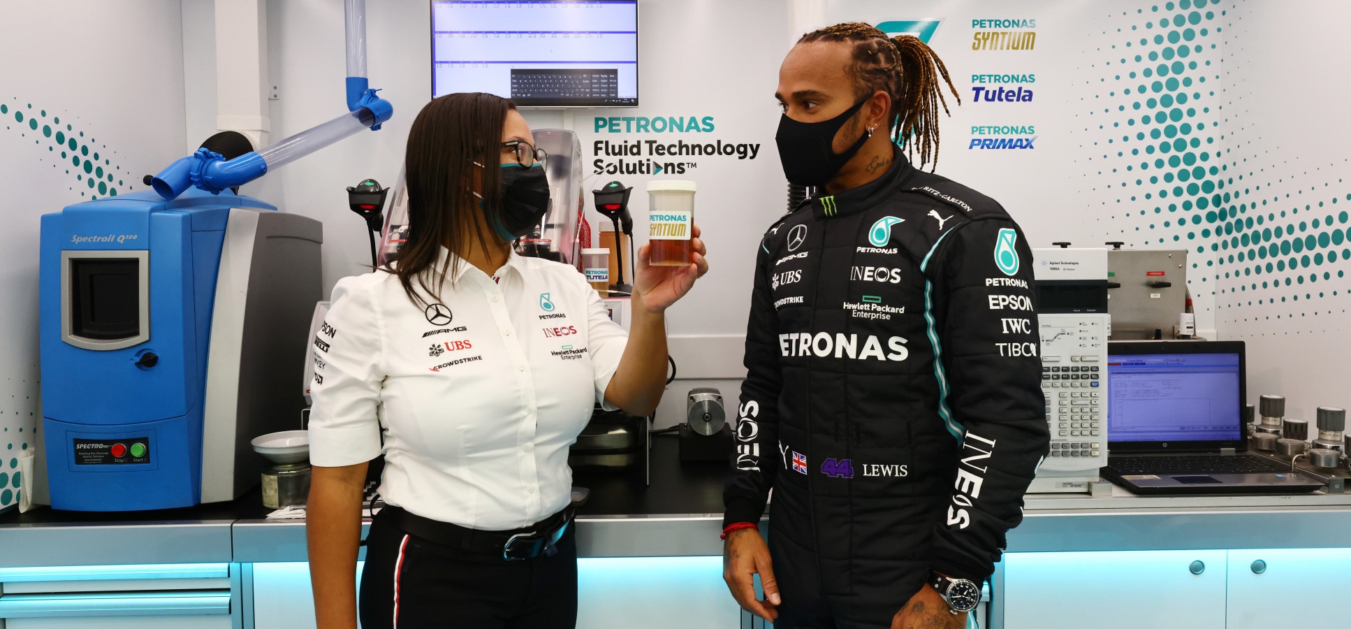 Stephanie Travers standing with F1 driver Lewis Hamilton