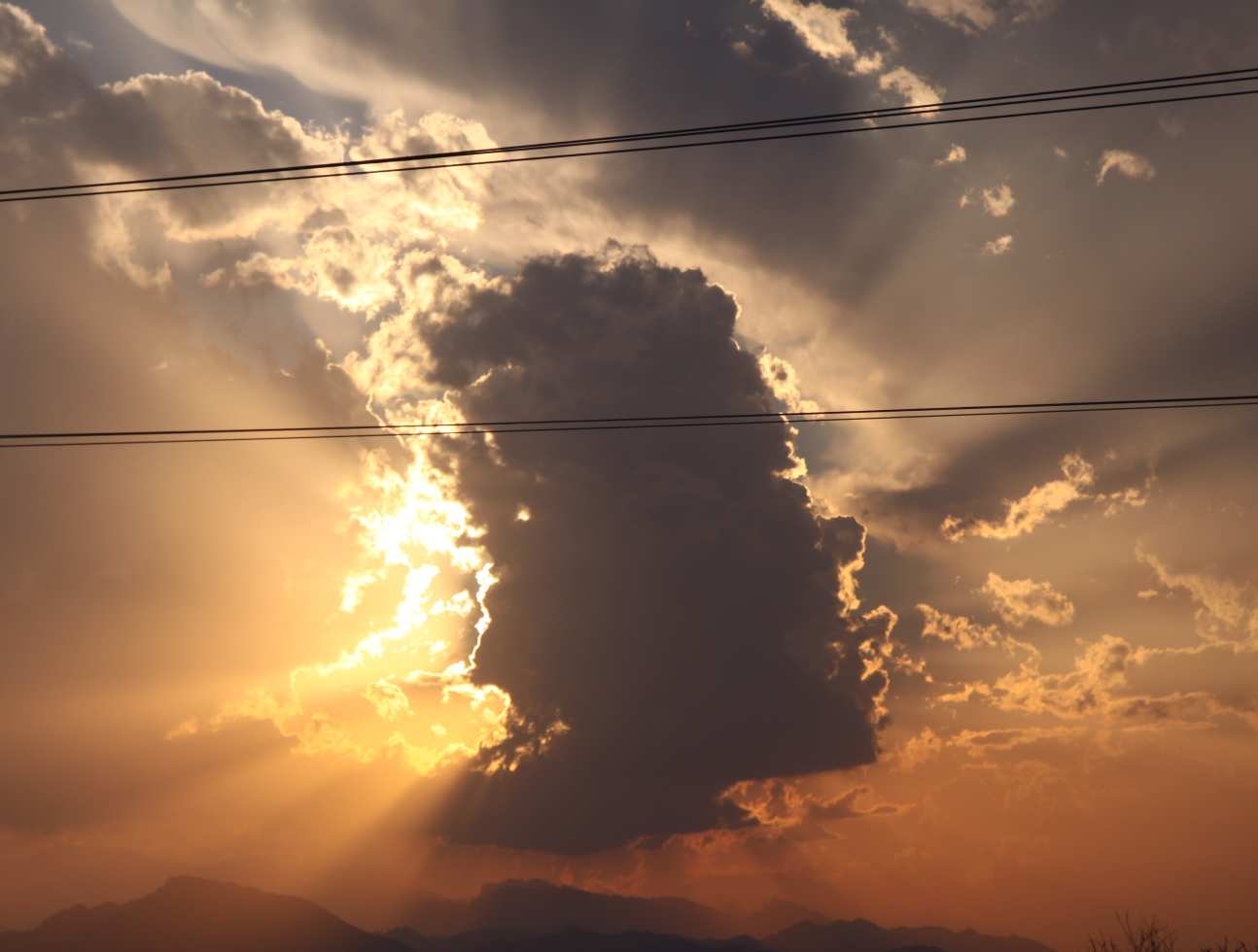 Orange sunrise behind grey cloud